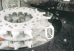 Spring-loaded fingers in two-level starwheel help stabilize a gallon jug during transfer at Ocean Spray's Henderson, NV, plant.