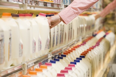 Man reaching for milk container in grocery store