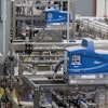 Near the end of the new canning line sits a tray packer that receives six-count cartons from an upstream cartoner and packs them into corrugated trays four per tray.