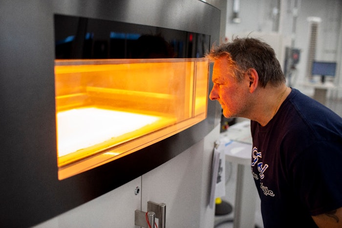 Dave Jacek, additive manufacturing technician, oversees production of 3D-printed disposable respirator mask prototypes at Ford's Advanced Manufacturing Center.