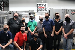 Surrounded by employees Alain Cerf (President and CEO of Polypack) stands proudly next to a recently finished machine.