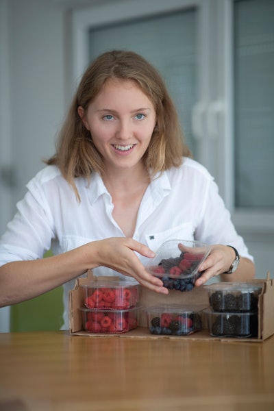 CEO Annika Baumann proudly showing secondary packaging filled with berries in rPET trays with flexible film lidding.