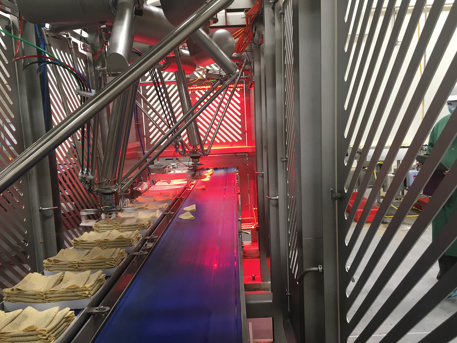 Fresh tacos that were once too hot to handle manually are now placed into trays by JLS Talon robots.