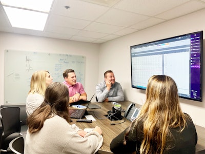 Joe Schaffer, Brent Bunker, Briana Helt, Hannah Rios, and Monica Hubrich of the Felins Finance team collaborate on a project.