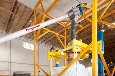 The flexible screw conveyor transfers ground coffee from the grinder through downspouting to the bulk bag filler.