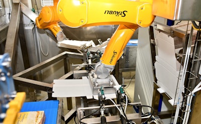 In the foreground, the TX2-60L robot, or ‘Franz,’ presses a carton blank into a negative mold, while in the background, the TX2-60, or ‘Sissi,’ readies four wrapped strudel for packing into the carton.