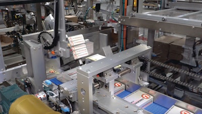 Cartons are formatted to 2x5 stacks, then oriented by turning 90 deg on-edge, prior to three-sided containment and a pusher loading them into a corrugated case.