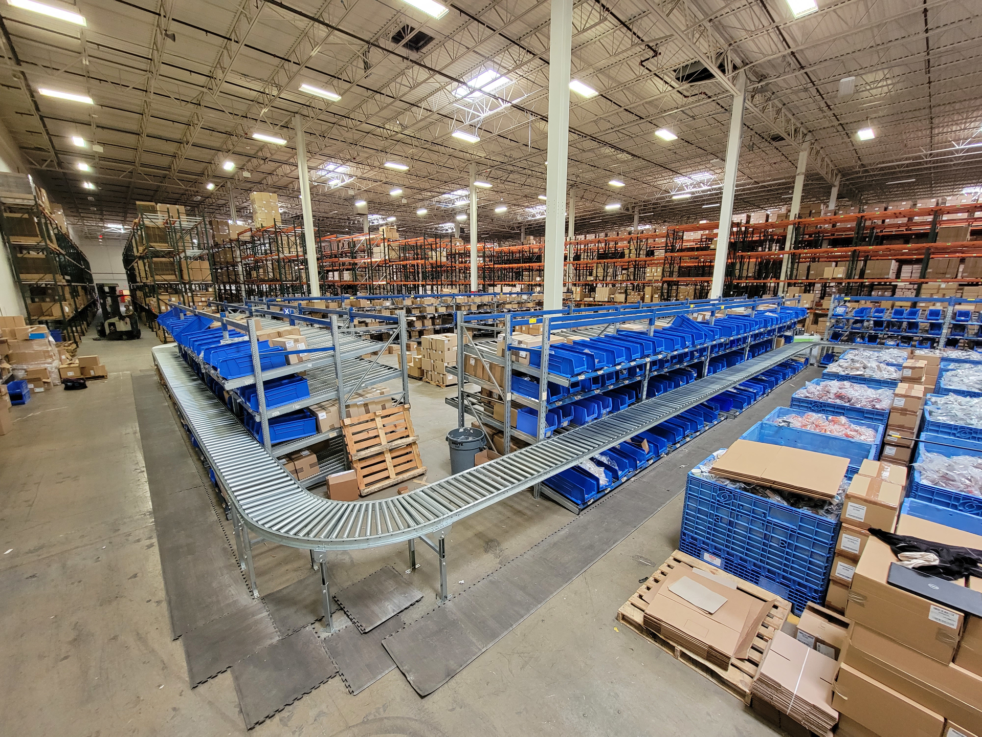 The updated layout in this fulfillment center keeps gravity fed cases moving smoothly through picking station, around elbows, and down to taping and palletizing.