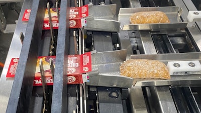 Upstream of secondary packaging, the single-serve pies are loaded into cartons on this system.
