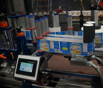 Full-wrap pressure-sensitive labels are applied just before bottles reach the case packer.