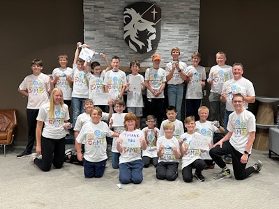 Summer Manufacturing Camp attendees and supervisors, including Todd Kruse (right), pose for a group photo at Legacy Christian Academy.