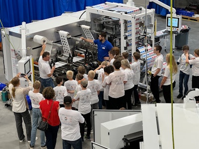 Todd Kruse explains packaging machinery to camp attendees at the Delta ModTech manufacturing plant.