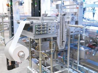 In an added module, wax paper is cut from rollstock, and placed by SCARA robot with vacuum grippers between layers of product.