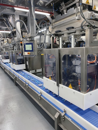 Shown here are three of the eight twin-bagger discharge stations that deposit 0.8-oz bags of gummies onto the conveyor that carries them to a cartoning operation.