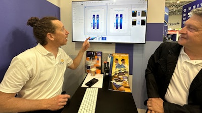 Epaud (left) and Werle demonstrate carton packaging review, commenting, and approval prior to printing the carton by cutting metal cylinders and printing 2D blanks to be erected.
