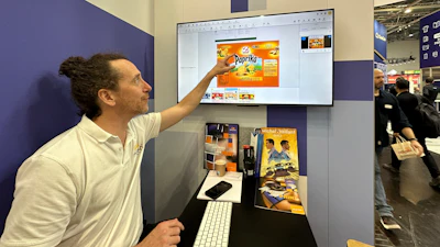 Dalim's Flaurent Epaud demonstrates Dalim ES Fusion platform at drupa, with an example of a chip bag from Swiss brand Zweifel potato chips.
