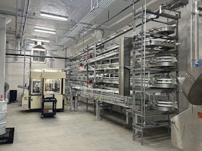 Assembled ice cream cartons gather on a Dyco Inc. staging area, before moving down to filling through a drop chute.