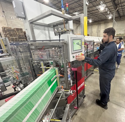 Workers fire up Korpack’s new cartoning machine.