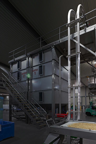 Industrial modular office unit with external staircase and ventilation system in factory warehouse setting