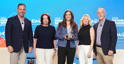 Five professionals posing together at the 2026 DAC Distributor Conference with an award.