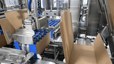 One group of 24 bottles has just been swept onto a corrugated case while the next group is collated and ready to be swept onto the next case.