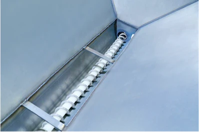 Close-up of white plastic gutter connectors and metal drainage pipe on building exterior against blue sky