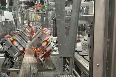 Eight paperboard carriers at a time are picked from magazine feeds and erected so that they can be picked and placed into corrugated cases that can be seen on the right.