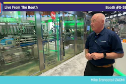 Man in navy polo shirt presenting industrial packaging equipment at PACK EXPO booth S-3847