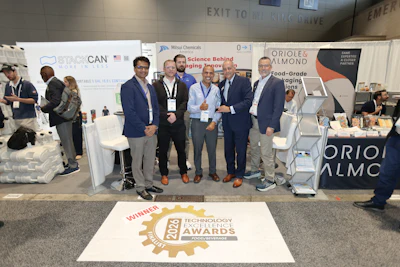 Group of business professionals posing at trade show booth with 2028 Technology Excellence Awards winner badge displayed